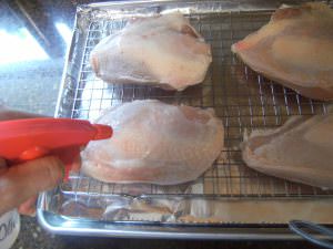 Spray chicken breasts with olive oil.