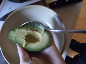 scooping an avocado for homemade guacamole