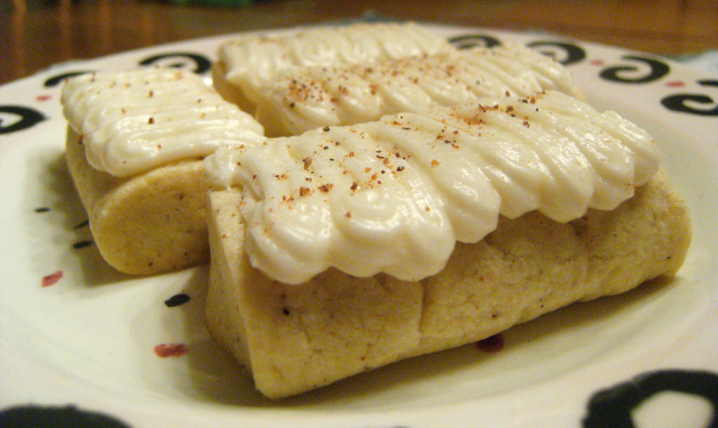 Egg-Nog-Logs are soft butter cookies infused with the flavors of egg nog, then topped with a rum flavored buttercream frosting. Alcohol free! - Get the holiday cookie recipe on www.ComfortablyDomestic.com