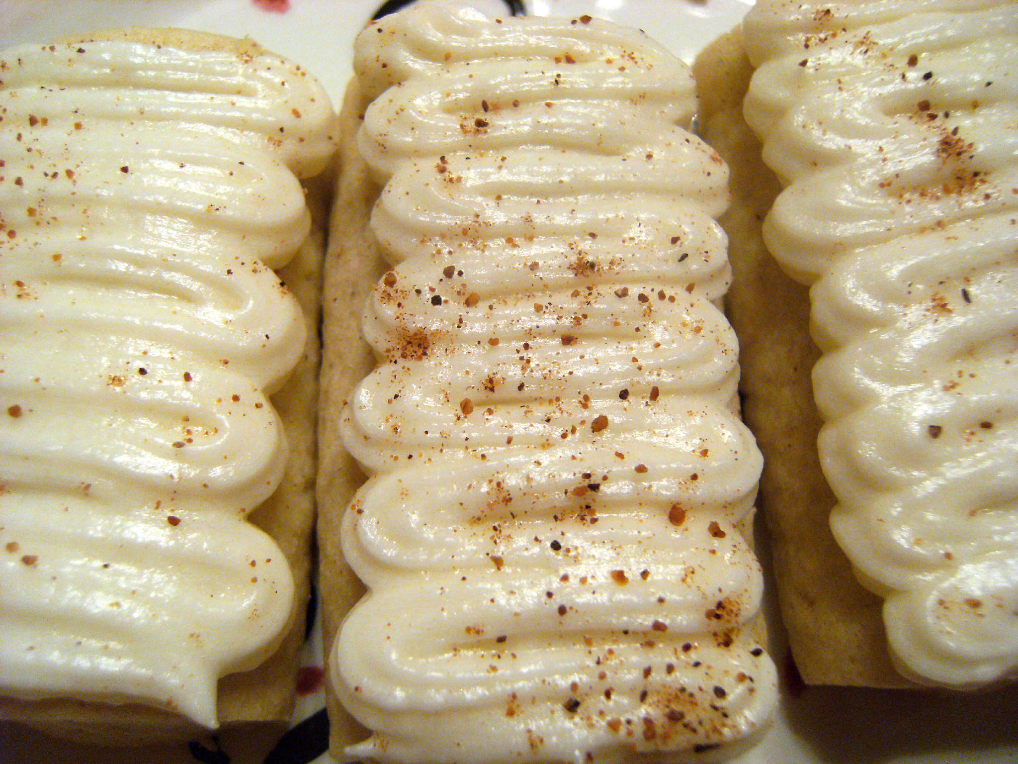 Egg-Nog-Logs are soft butter cookies infused with the flavors of egg nog, then topped with a rum flavored buttercream frosting. Alcohol free! - Get the holiday cookie recipe on www.ComfortablyDomestic.com