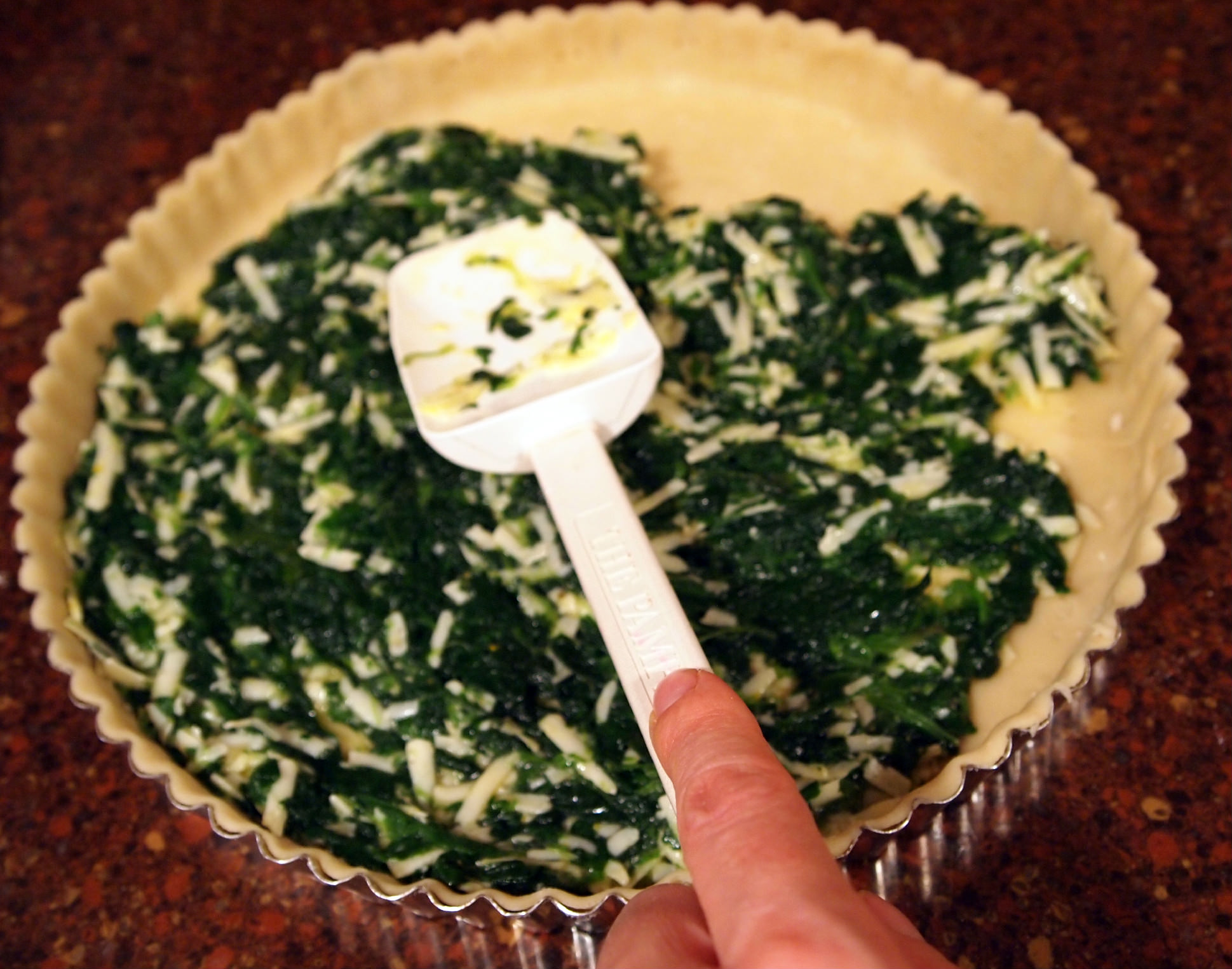 spreading filling into a spinach tart