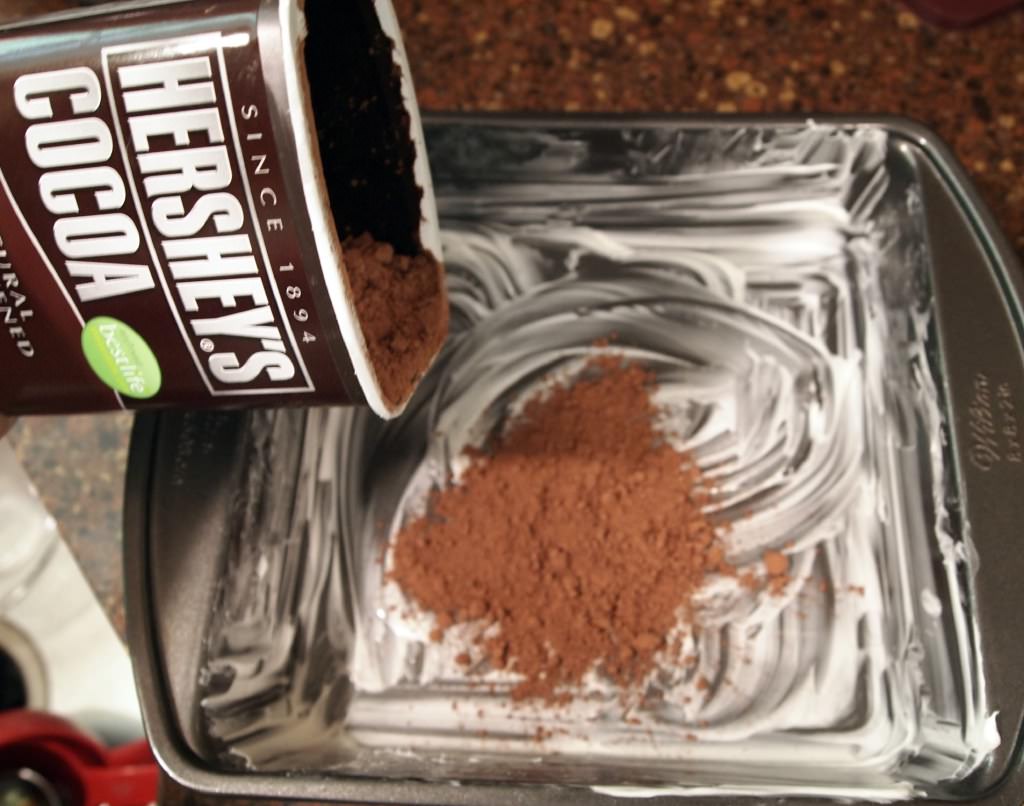 greasing a cake pan and dusting it with cocoa powder