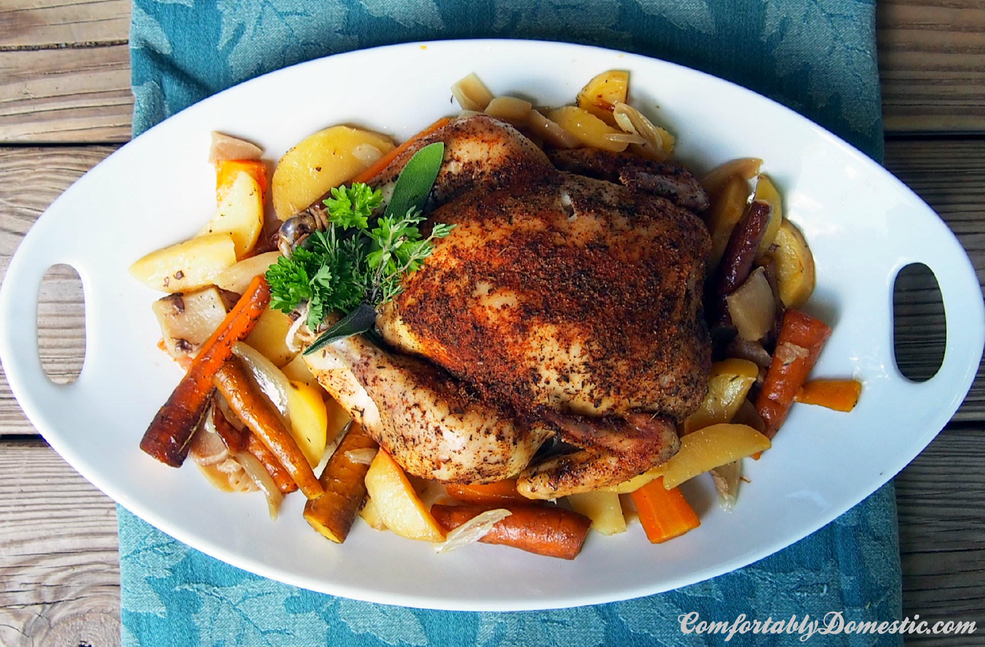Slow cooker whole roasted chicken is the perfect dinner! Succulent, seasoned chicken on a bed of root vegetables, slow roasted all day for a flavorful and fragrant weeknight meal. | ComfortablyDomestic.com