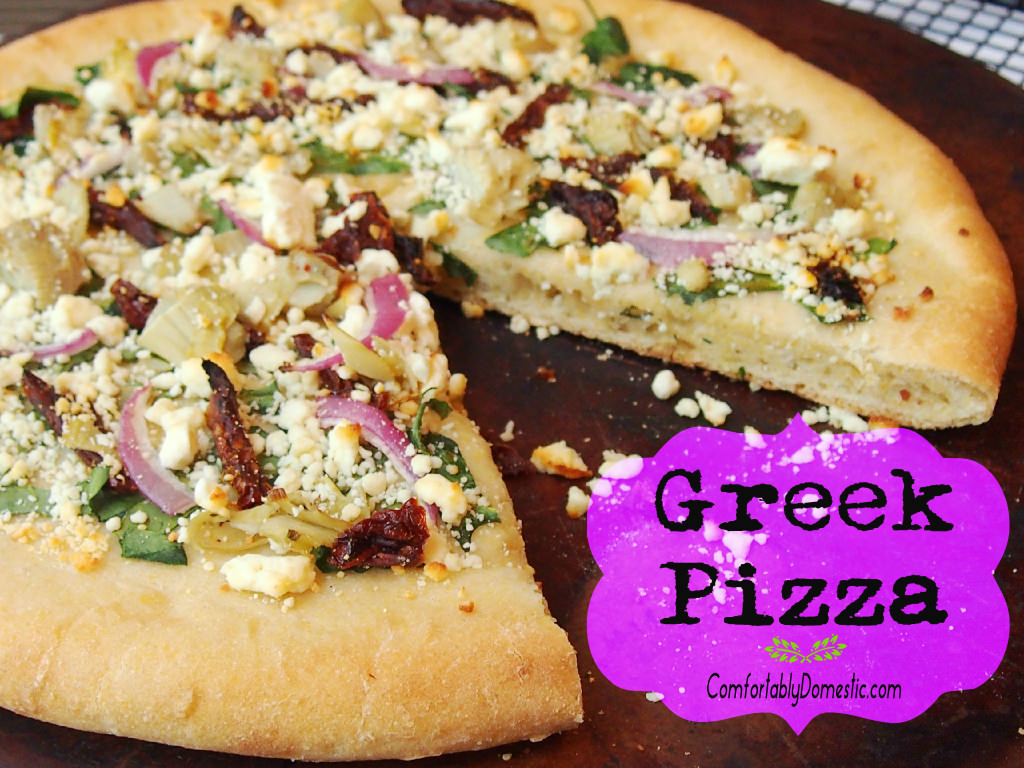 Greek Pizza starts with a tangy tzatziki sauce that unites such Mediterranean flavors as artichoke hearts, sundried tomatoes, spinach, red onion, and a feta cheese into tantalizing, cornmeal-crusted pizza. | ComfortablyDomestic.com