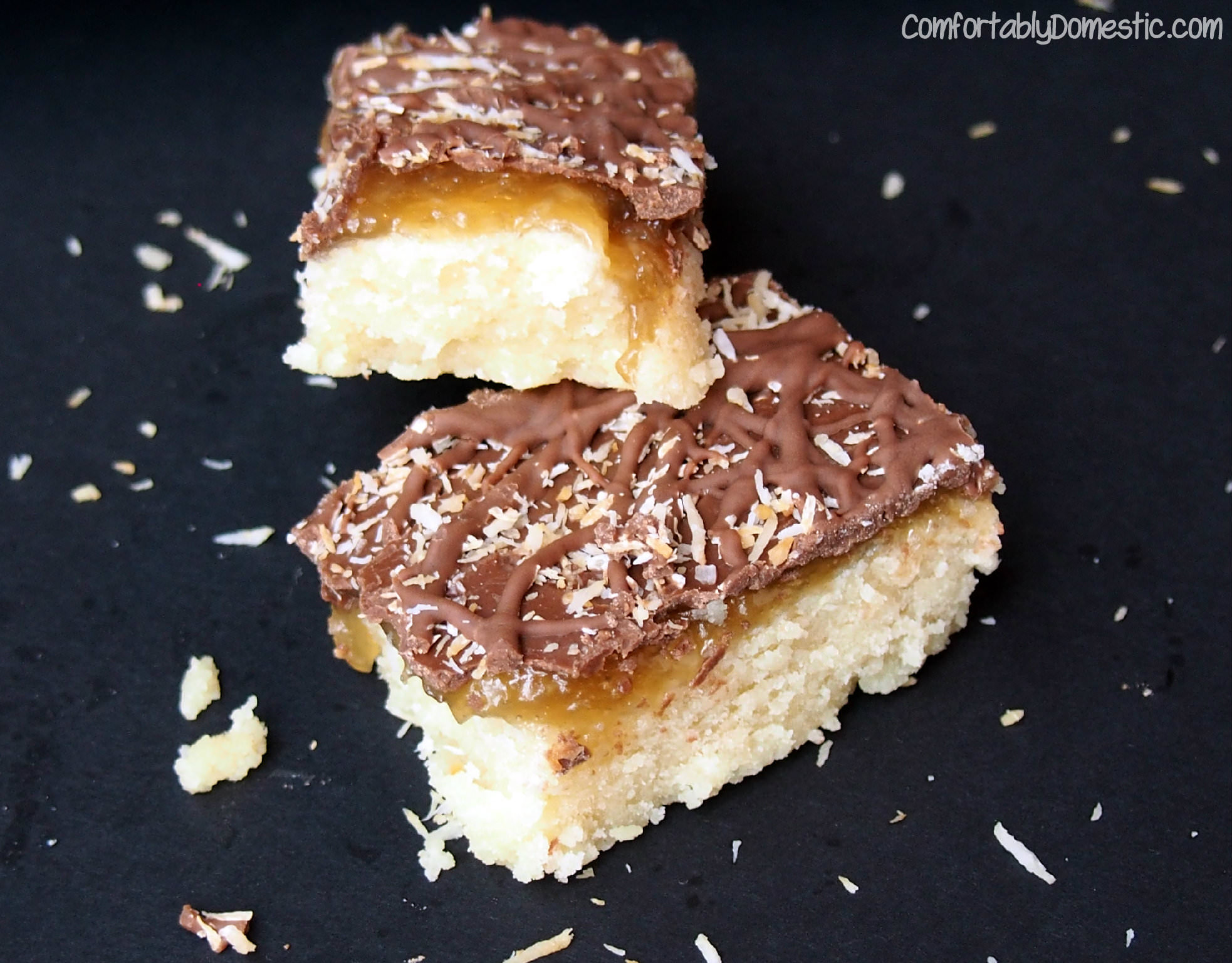 Samoa Bars are reminiscent of the popular Girl Scout Cookie. Crisp, buttery shortbread, smothered with a thin layer of dreamy salted coconut caramel, then topped with rich dark chocolate and toasted coconut. | ComfortablyDomestic.com
