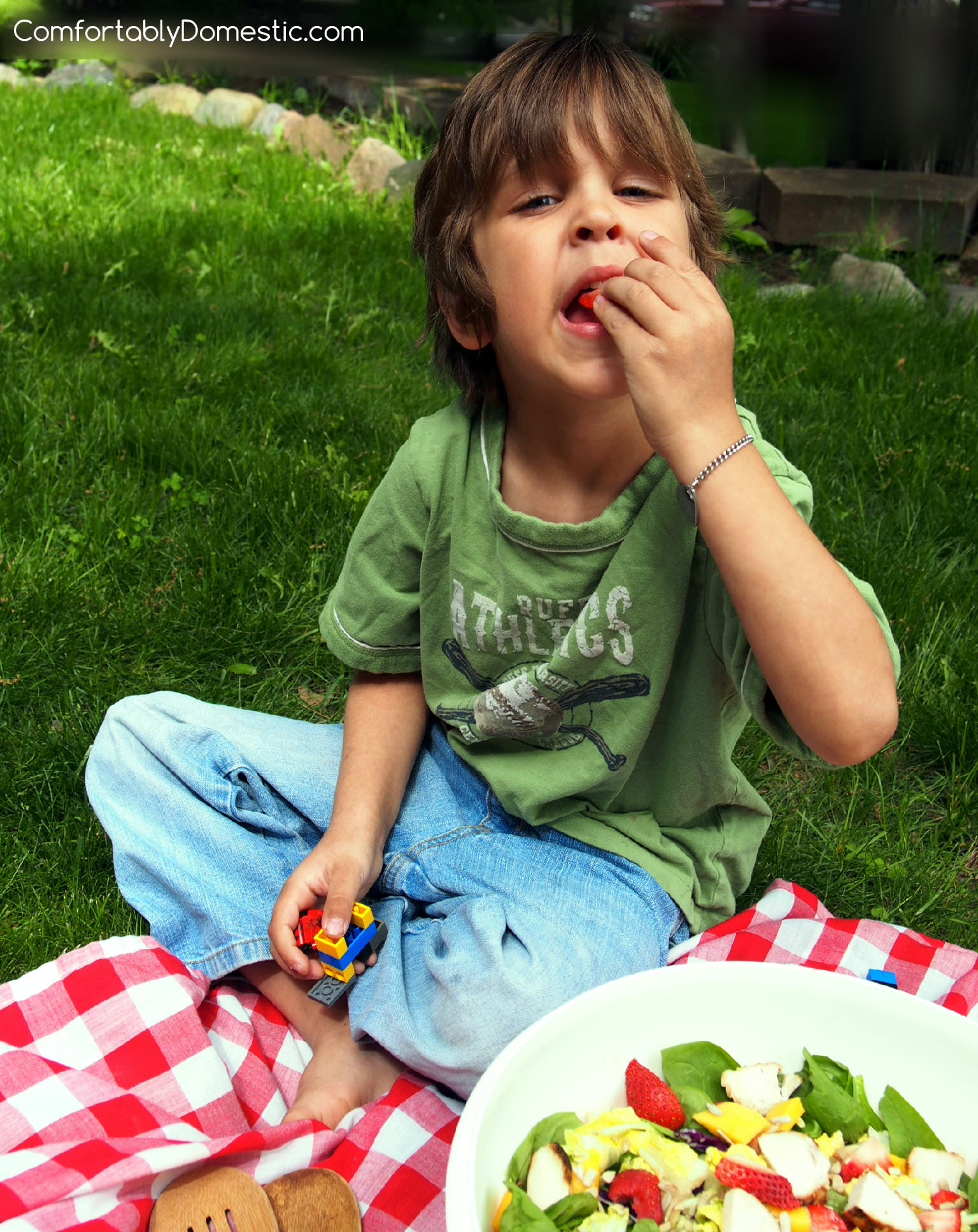 The Baby plucking strawberries out of the salad.