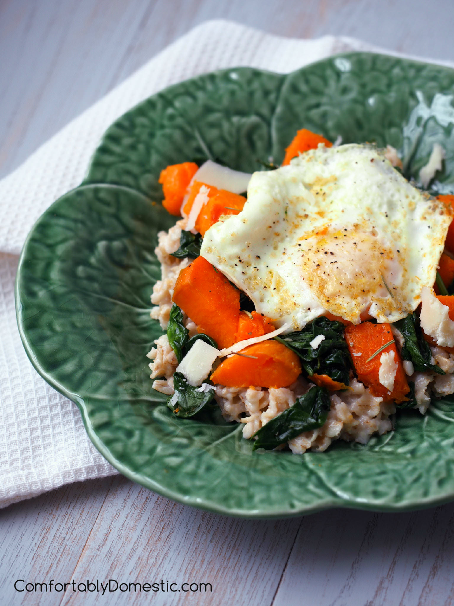 Savory oats are an infinitely satisfying way to start the day! Vibrant spinach, roasted sweet potatoes, and a farm fresh egg rest atop a bed of healthy oats for a delicious breakfast. | ComfortablyDomestic.com