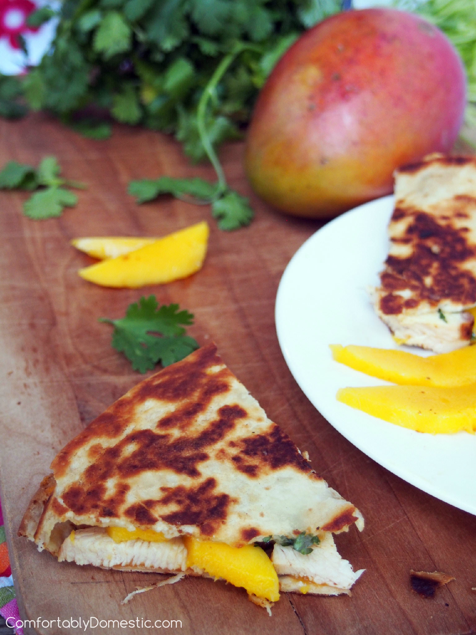Mango chicken quesadillas start with tender grilled chicken, fresh mango slices, and creamy brie cheese. They're layered and toasted between buttery flour tortillas. They are a great use for leftover chicken, making a healthy lunch or quick snack. | ComfortablyDomestic.com