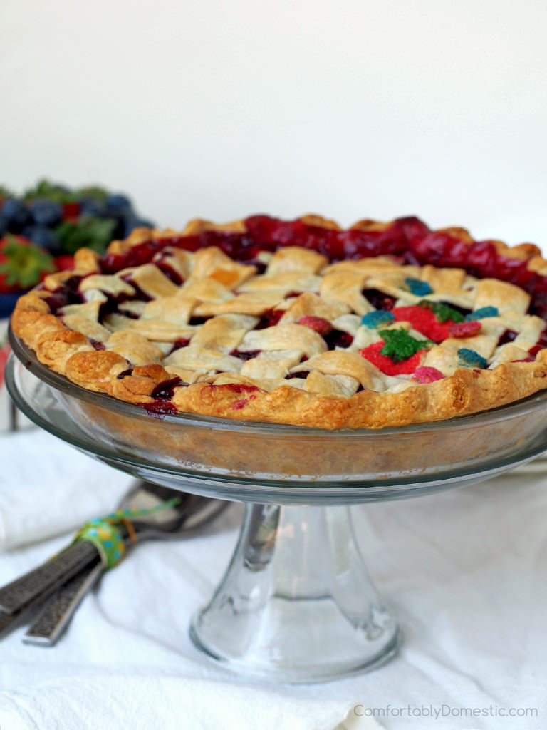 Mixed berry pie that is as delightfully inviting as summer itself. Fresh, sweet strawberries, juicy blueberries, and tart raspberries happily mingle together in a flaky pastry crust.  | ComfortablyDomestic.com