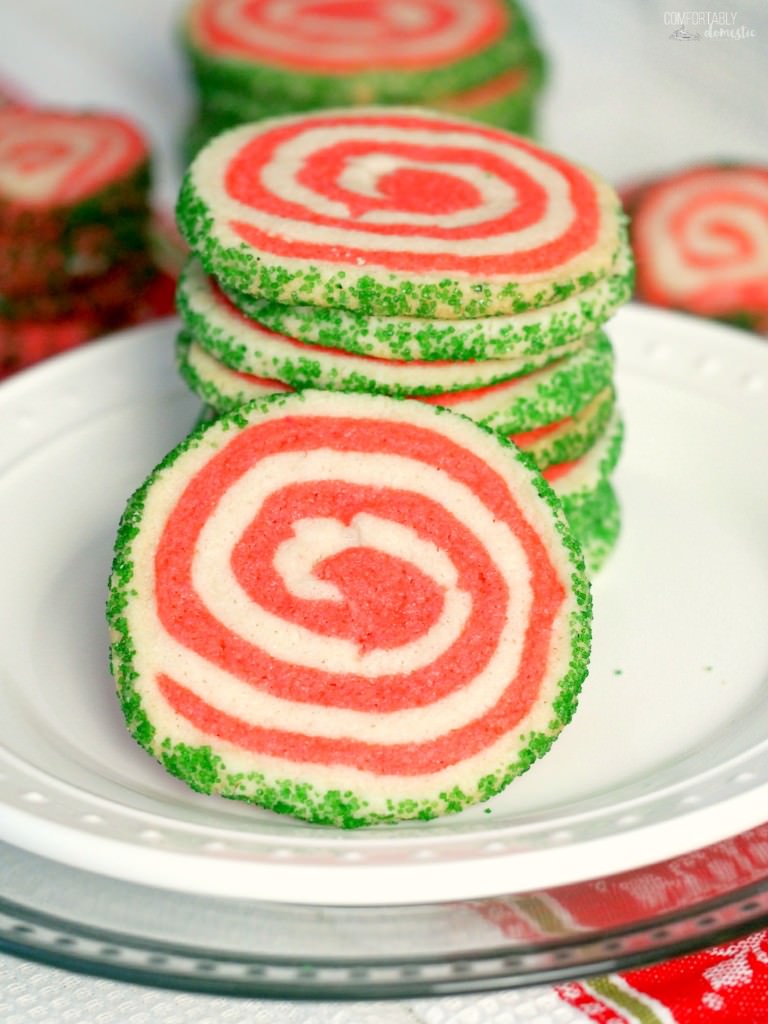 Peppermint shortbread pinwheel cookies are the perfect cookie recipe to make for your holiday cookie platter! Buttery vanilla and peppermint shortbread, presented in a fun pinwheel design. Edged in colored sugar, for an added touch of holiday sparkle. | ComfortablyDomestic.com