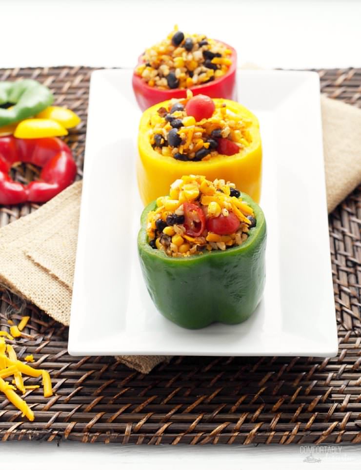 Vegetarian-Stuffed-Peppers-add-Tex-Mex flavor to sweet bell peppers filled with a combination of chewy brown rice, tender black beans, garden fresh vegetables, tangy cheese, and blend of southwest seasonings to make these healthy morsels anything but bland or ordinary.