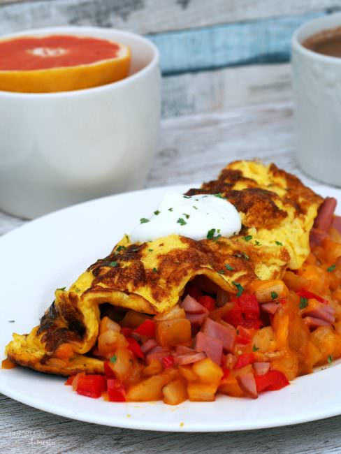 Farmer’s Omelet wraps diced sweet red peppers, sweet onion, hash browns, Canadian bacon, and cheese in fluffy eggs for a hearty breakfast with serious staying power to keep you going all morning long.
