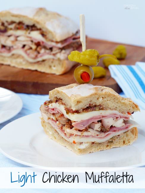 Light-Chicken-Muffaletta-Sandwich takes a healthier spin with tender chicken, smoked ham, provolone, and the classic olive salad sandwiched between soft and crusty bread.