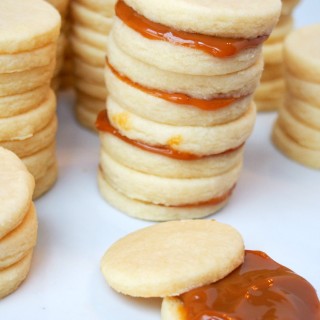 Alfajores are simple, buttery shortbread sandwich cookies filled with dulce de leche, popular in Latin American countries. | ComfortablyDomestic.com