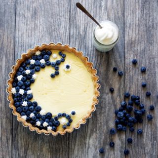Vanilla-Custard-Tart-with-Blueberries-and-Cream is a fresh and light summer dessert featuring creamy vanilla bean custard topped with a smattering of fresh blueberries and a touch of whipped cream.