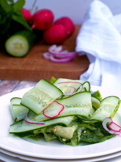 Cucumber-Ribbon-Salad tosses fun ribbons of ripe cucumber and other vegetables with a flavorful fresh pesto dressing in a cool and crunchy summer salad.