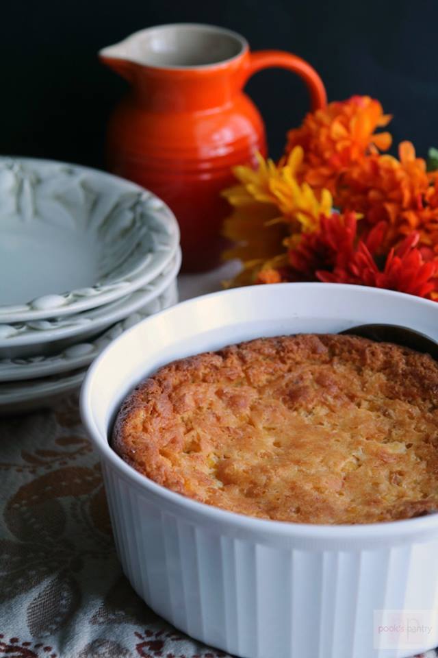 corn-casserole-in-white-bowl-with-orange-flowers-in-background