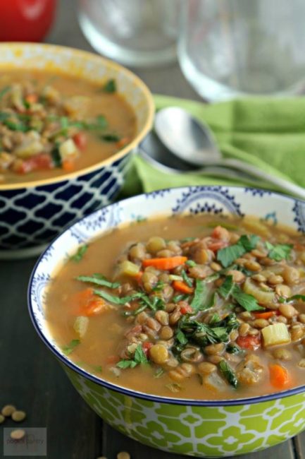 Two bowls of lentil soup with parsley sprinkled on top.