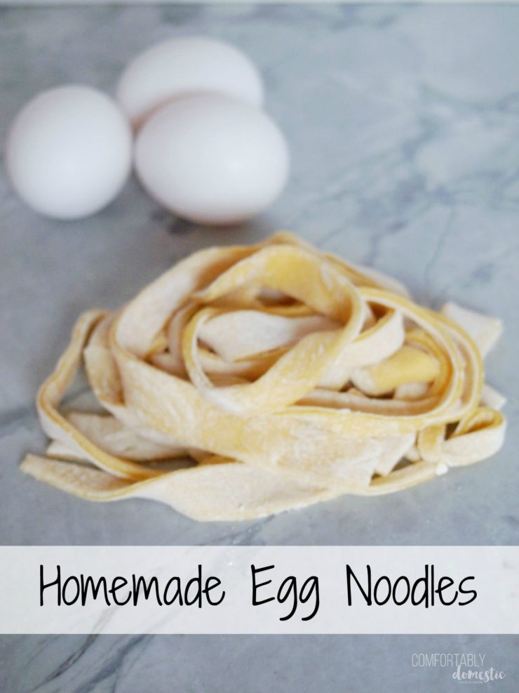 homemade-egg-noodles on white marble with eggs in the background