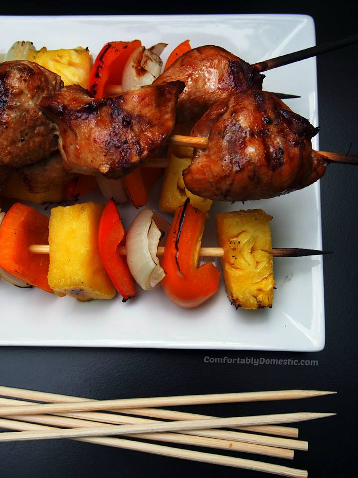 soy ginger chicken kabobs on a white plate on a black background.