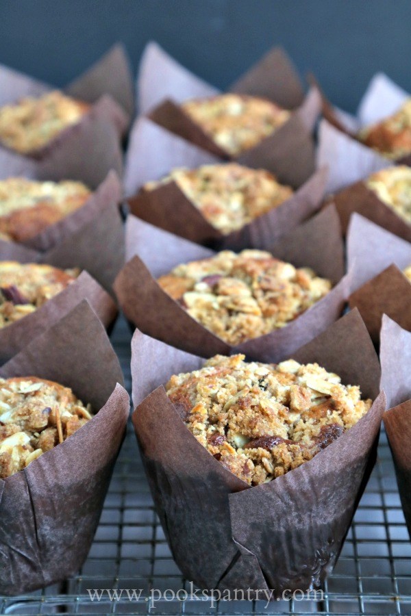 a dozen banana muffins in brown tulip style muffin wrappers.