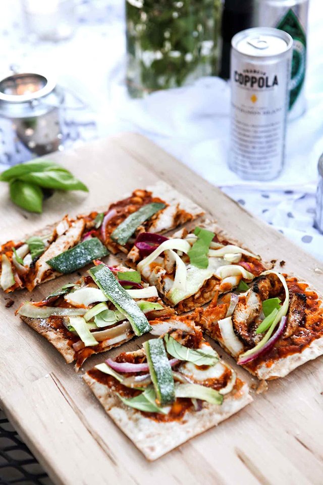 grilled bbq chicken pizza cut into squares on a cutting board