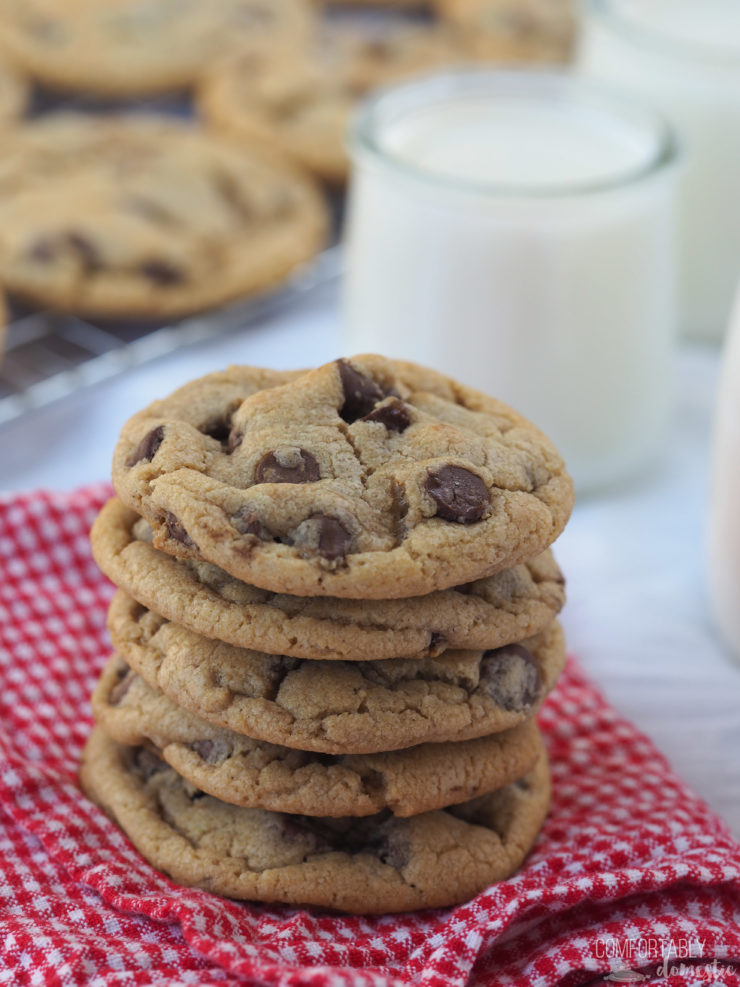 Close up of a stack of Mrs. Field's Chocolate Chip Cookies on a red gingham napkin.