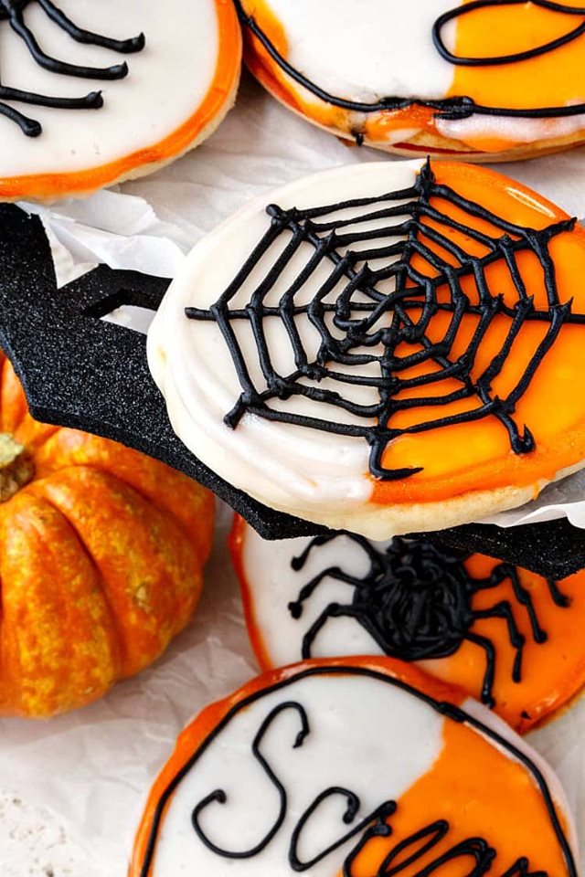 Halloween-black-and-white-cookies with spiders and webs piped on top.