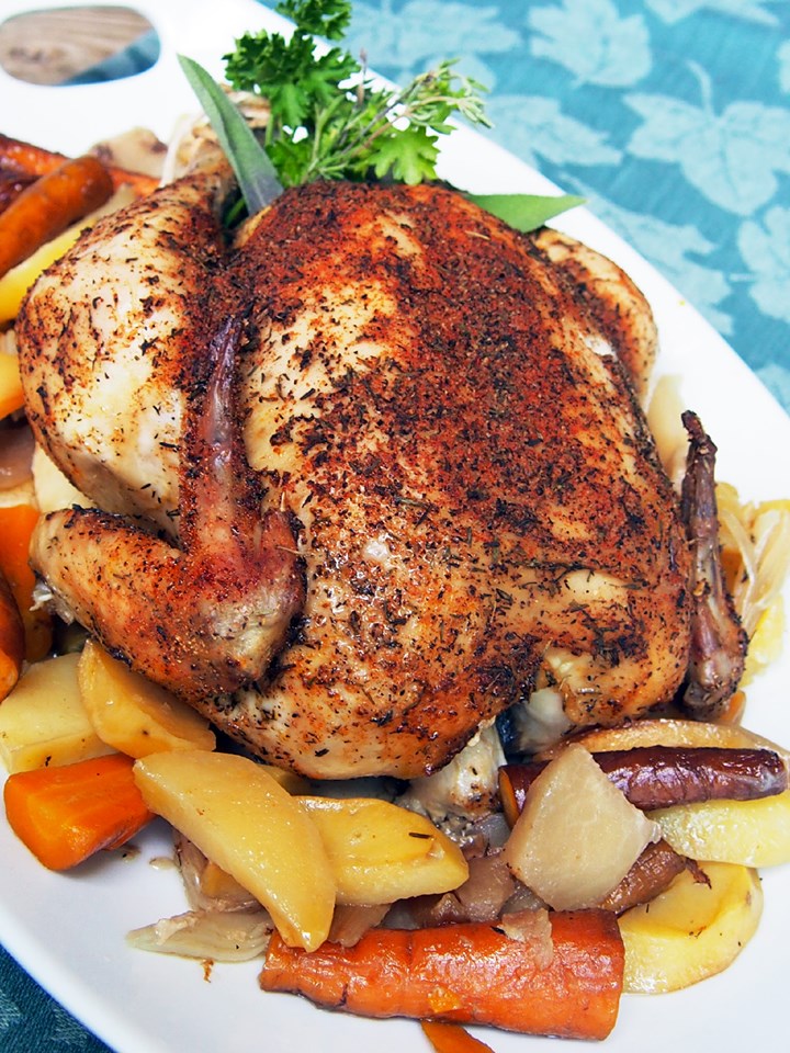 slow-cooker-whole-roasted-chicken with root vegetables on a large white platter.