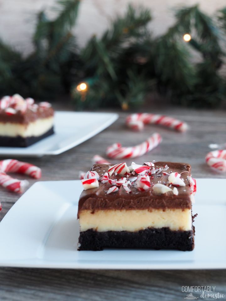 Several layered peppermint cheesecake brownies with candy canes scattered about.